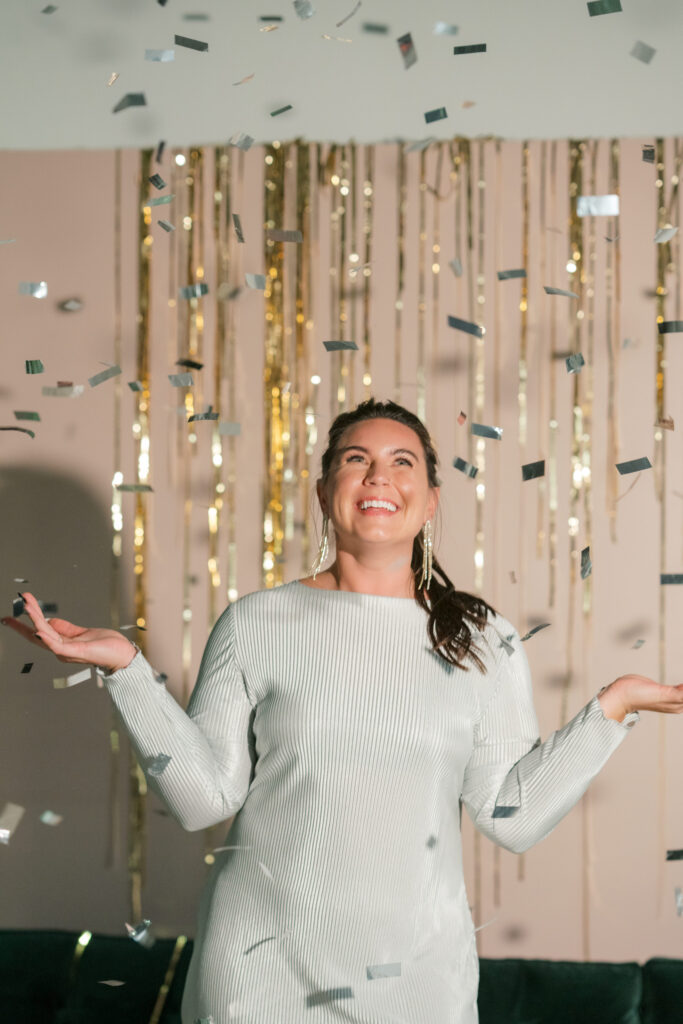 Sydney Meyer of In Ink Weddings stands as confetti falls around her.