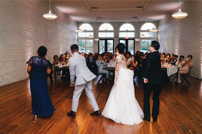 Bride and groom and their parents do a surprise dance in front of their guests at their reception - one of the cool wedding ideas they wanted to incorporated during their day.